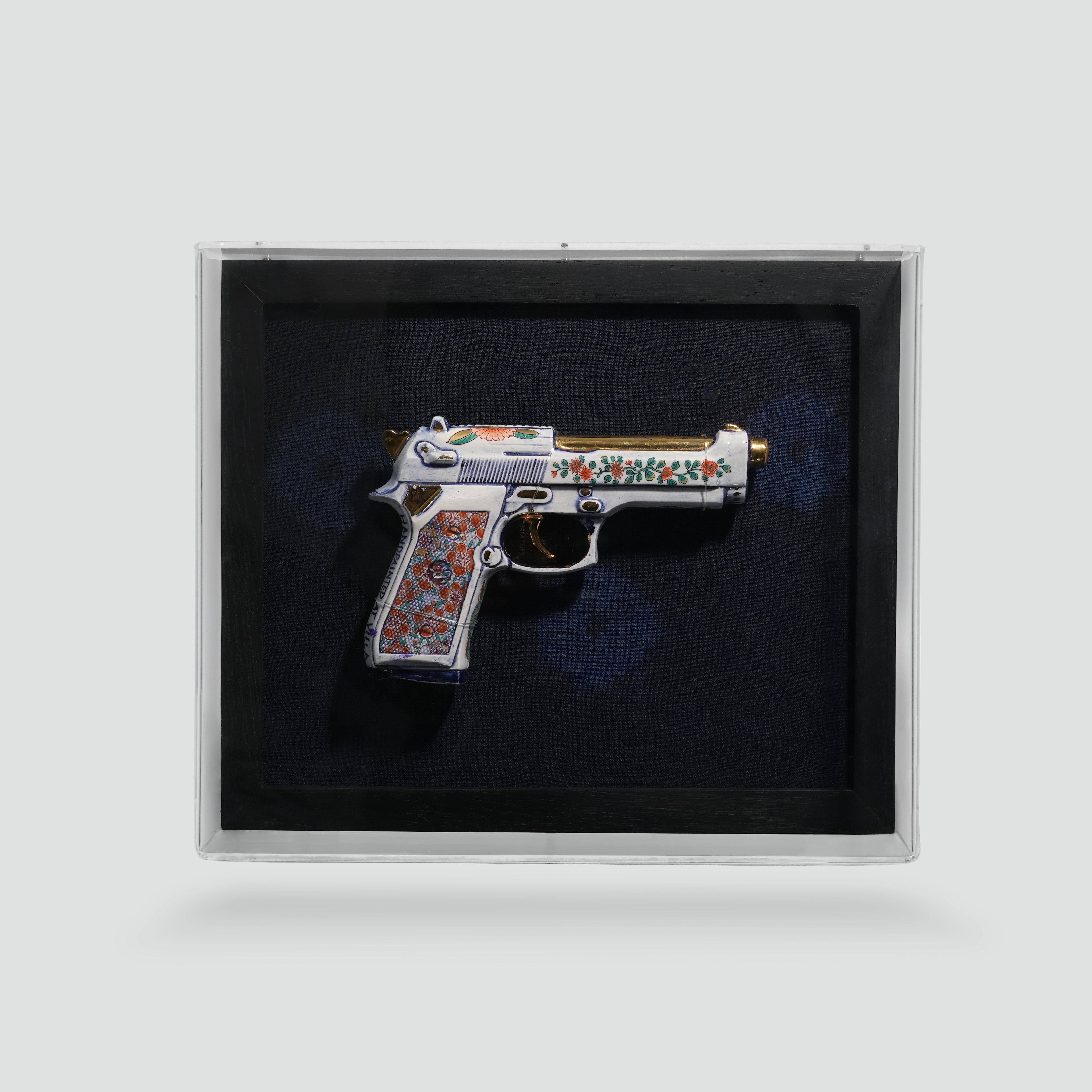 Ceramic Beretta 92 by Trevor Foster, cobalt porcelain with 24k gold, framed in a black shadow box under acrylic