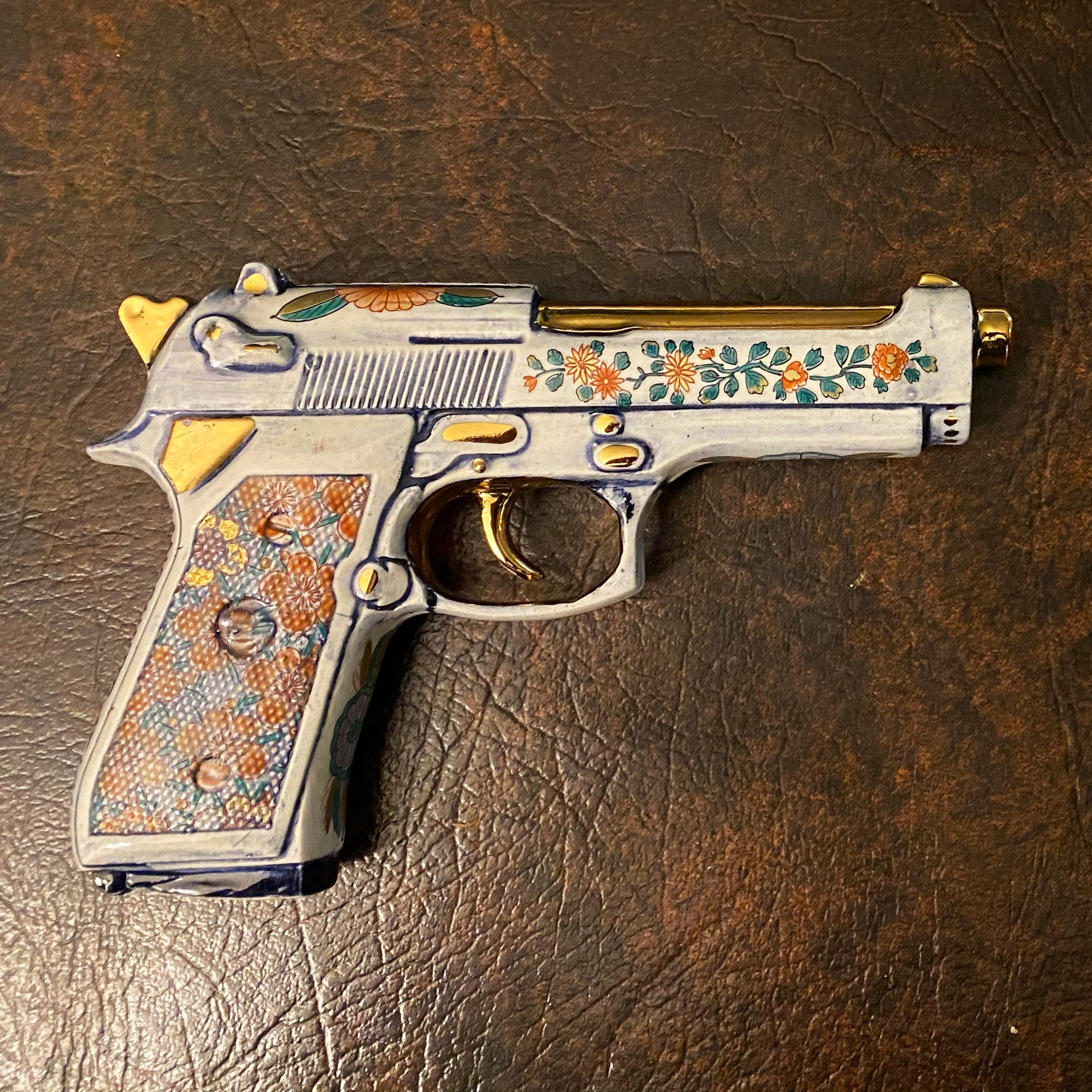 Full profile of the cobalt porcelain Beretta 92 with 24k gold barrel, trigger and hammer
