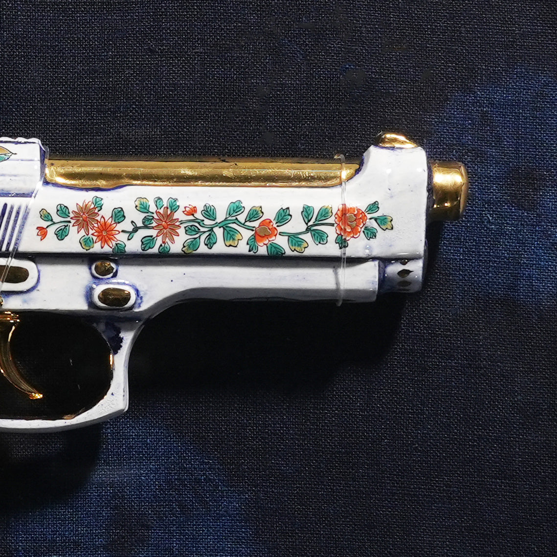 Detail of the slide: hand china-painted chrysanthemum and peony scroll over a 24k gold barrel