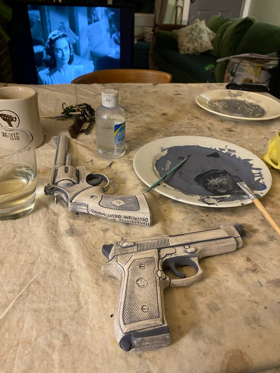 The unglazed porcelain Beretta 92 and revolver in the studio, in progress before the overglaze painting and final firing