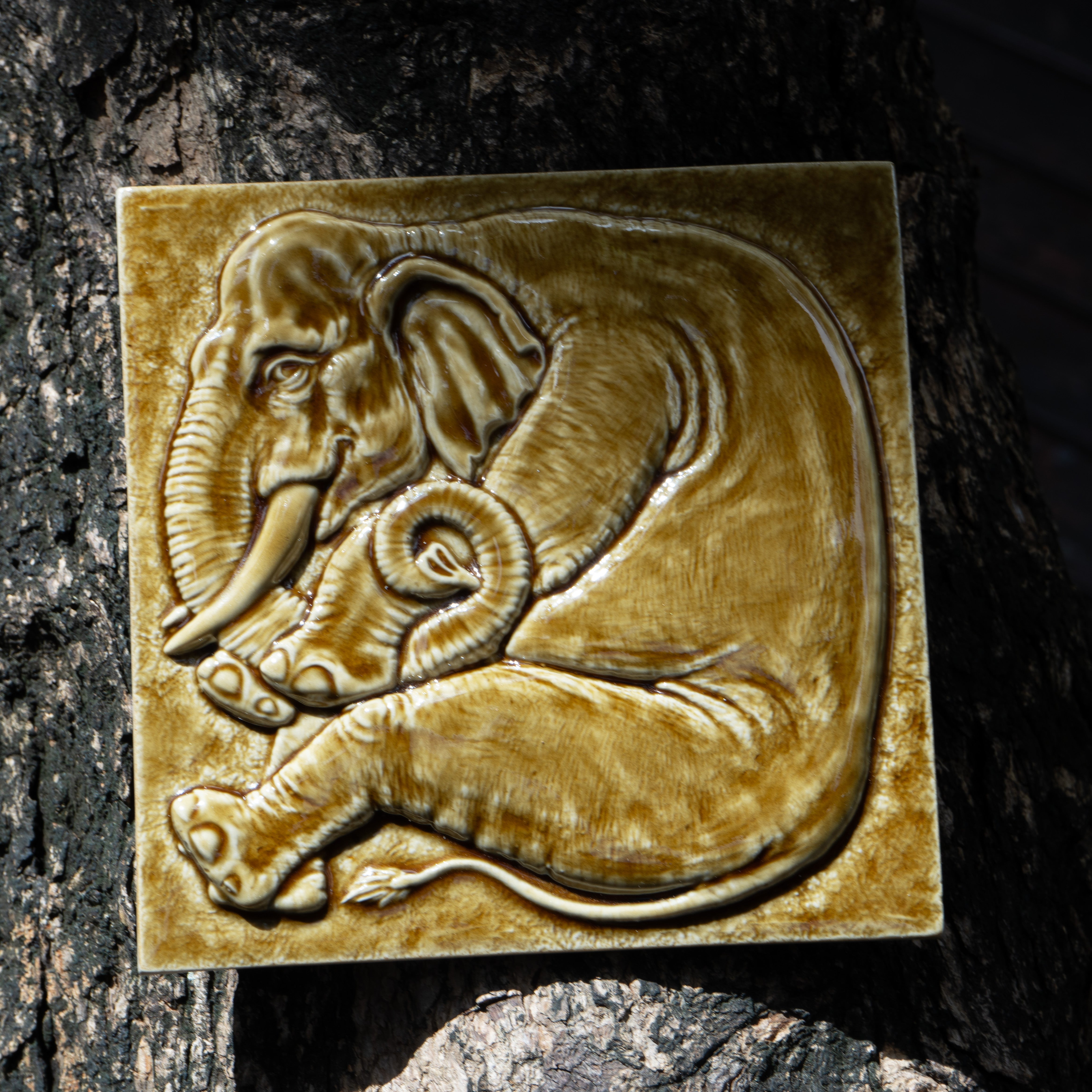 Amber elephant tile on bark
